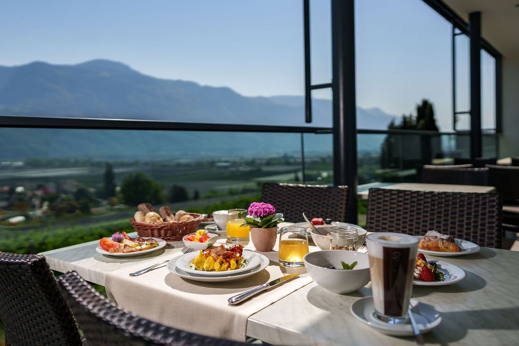Frühstückstisch auf Terrasse mit Bergblick, gedeckt mit verschiedenen Speisen und Getränken. Frühstückstisch auf Terrasse mit Bergblick, gedeckt mit verschiedenen Speisen und Getränken.